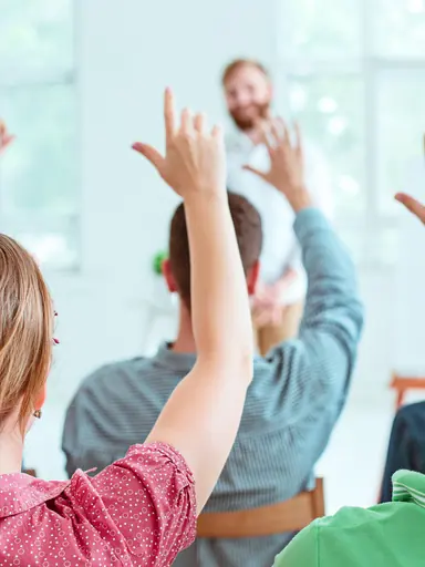 Plateia levantando as mãos em palestra da SIPAT
